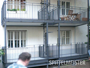 München. Stahlbalkon mit Treppe als Anbaubalkon, dunkle Farbbeschichtung und integrierten Fluchtleitern gemäß der Brandschutz Vorschrift. Balkonbauer München